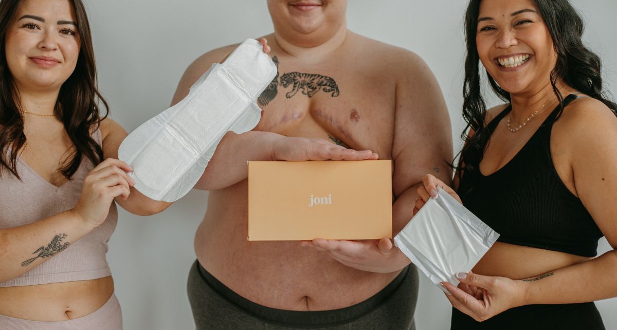 Trans man and two women hold period products