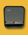 joni menstrual dispenser with non-applicator tampons on a vibrant yellow background.