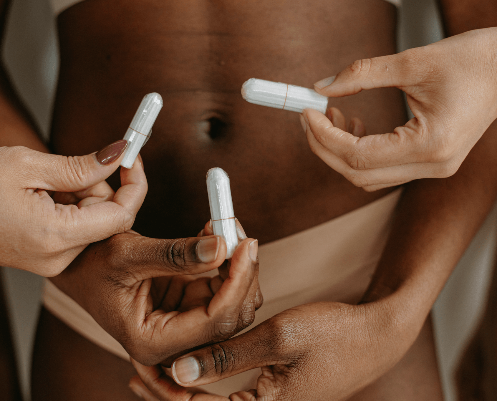 Hands holding regular organic cotton tampons without applicators, promoting eco-friendly menstruation solutions.
