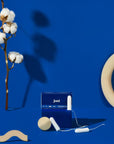 Super Organic Cotton Tampons by joni on blue background with cotton branch and decorative shapes.