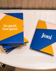 Travel period care mini boxes on a bathroom toilet, featuring bold graphics and empowering messages.
