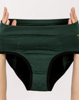 Dark green joni high-waisted leakproof period underwear briefs held up by a person's hands against a plain light background.