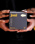 Two hands holding a box of joni organic bamboo incontinence pads, featuring 16 ultra-absorbent pads.