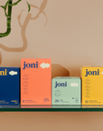 Various joni feminine hygiene products displayed on a shelf, including menstrual pads and bamboo liners.