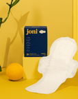 Organic bamboo super pads by joni, featuring a sleek design against a vibrant yellow backdrop.