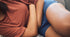Close-up of a person holding their abdomen, indicating discomfort possibly related to menstrual issues.
