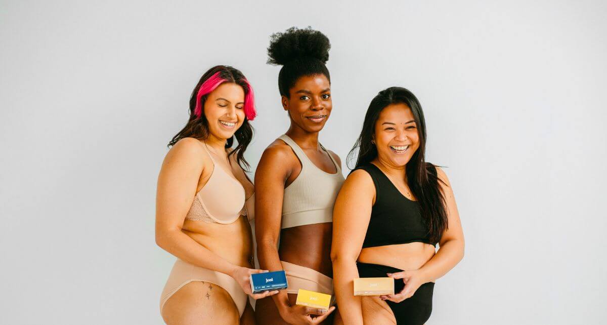 Three diverse women in their underwear holding joni period care