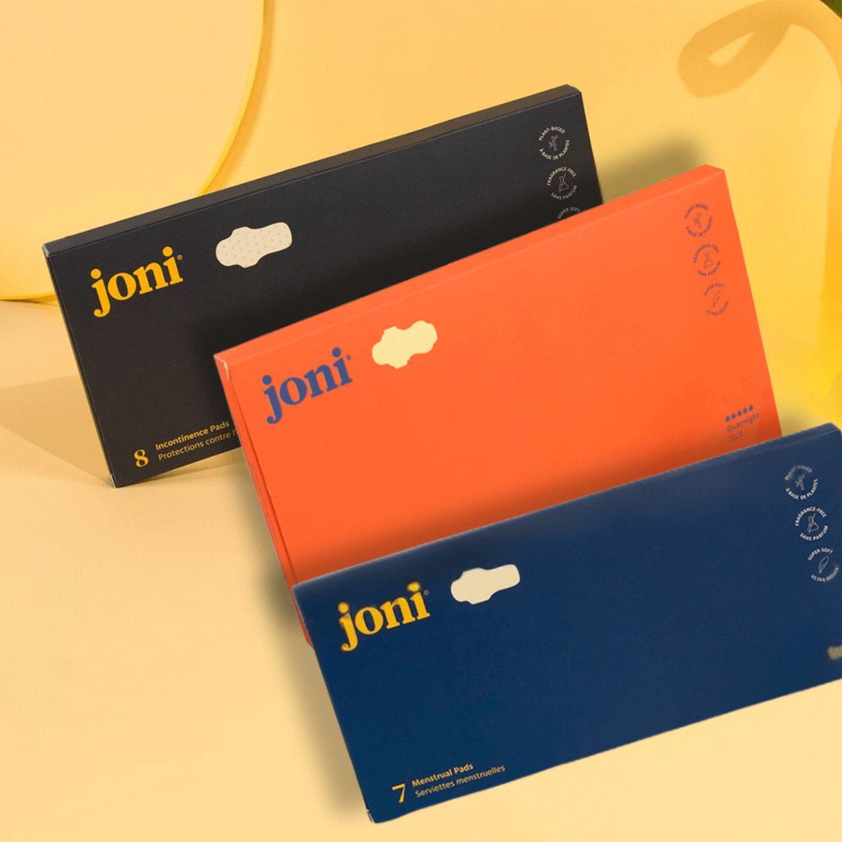 Postpartum Period Care Bundle featuring joni Organic Pads in black, orange, and blue packaging against a sunny backdrop.