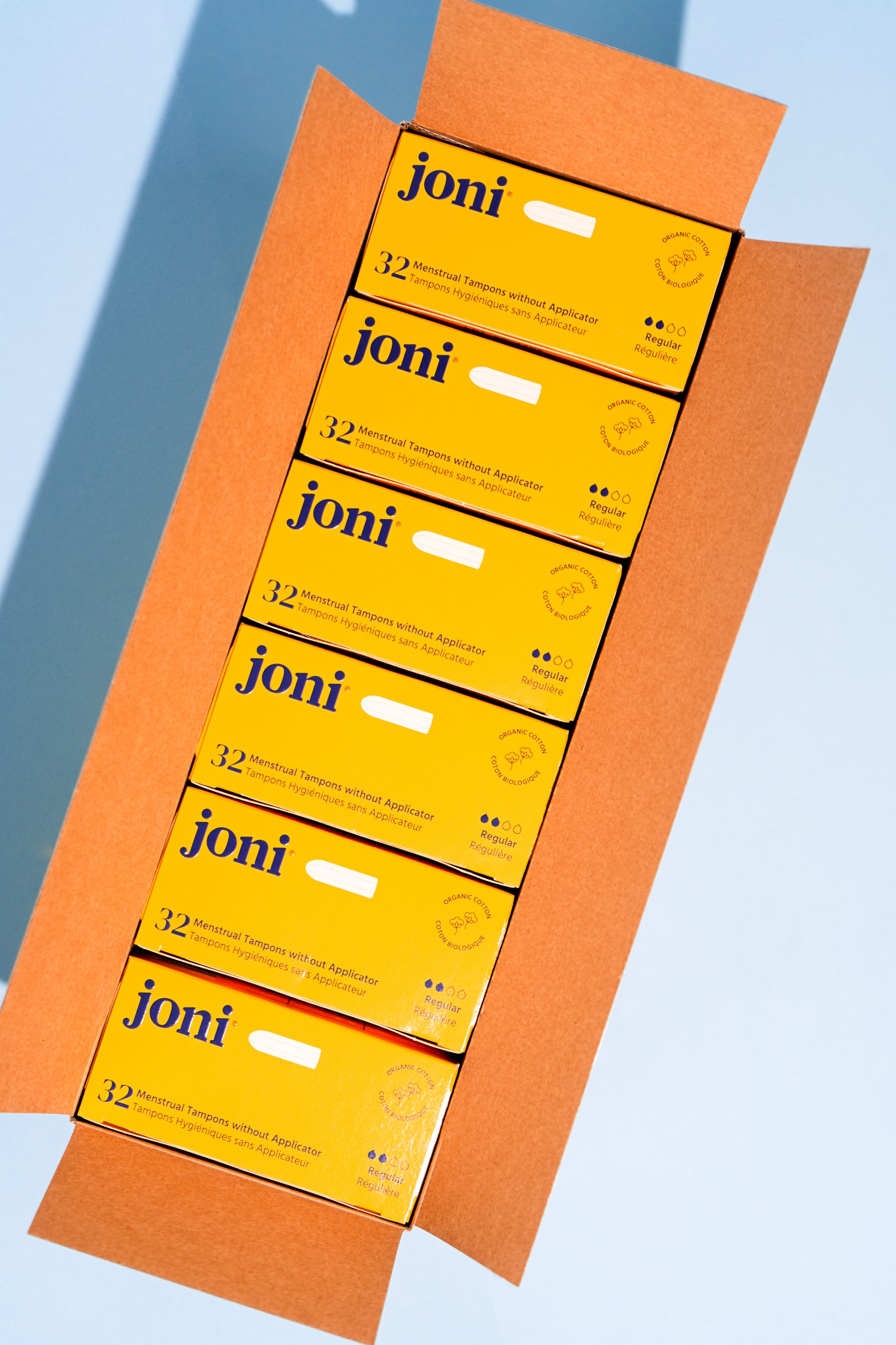 Open casepack of joni regular tampons for commercial washrooms with a blue background  